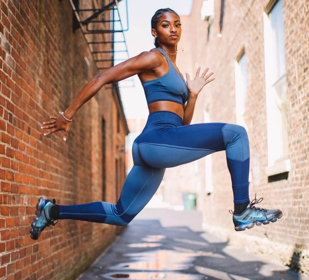 Athletic woman in blue workout outfit leaping