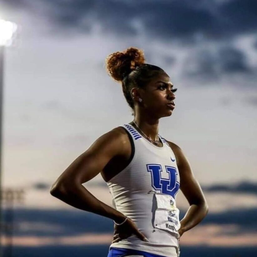 Female track athlete standing hands on hips