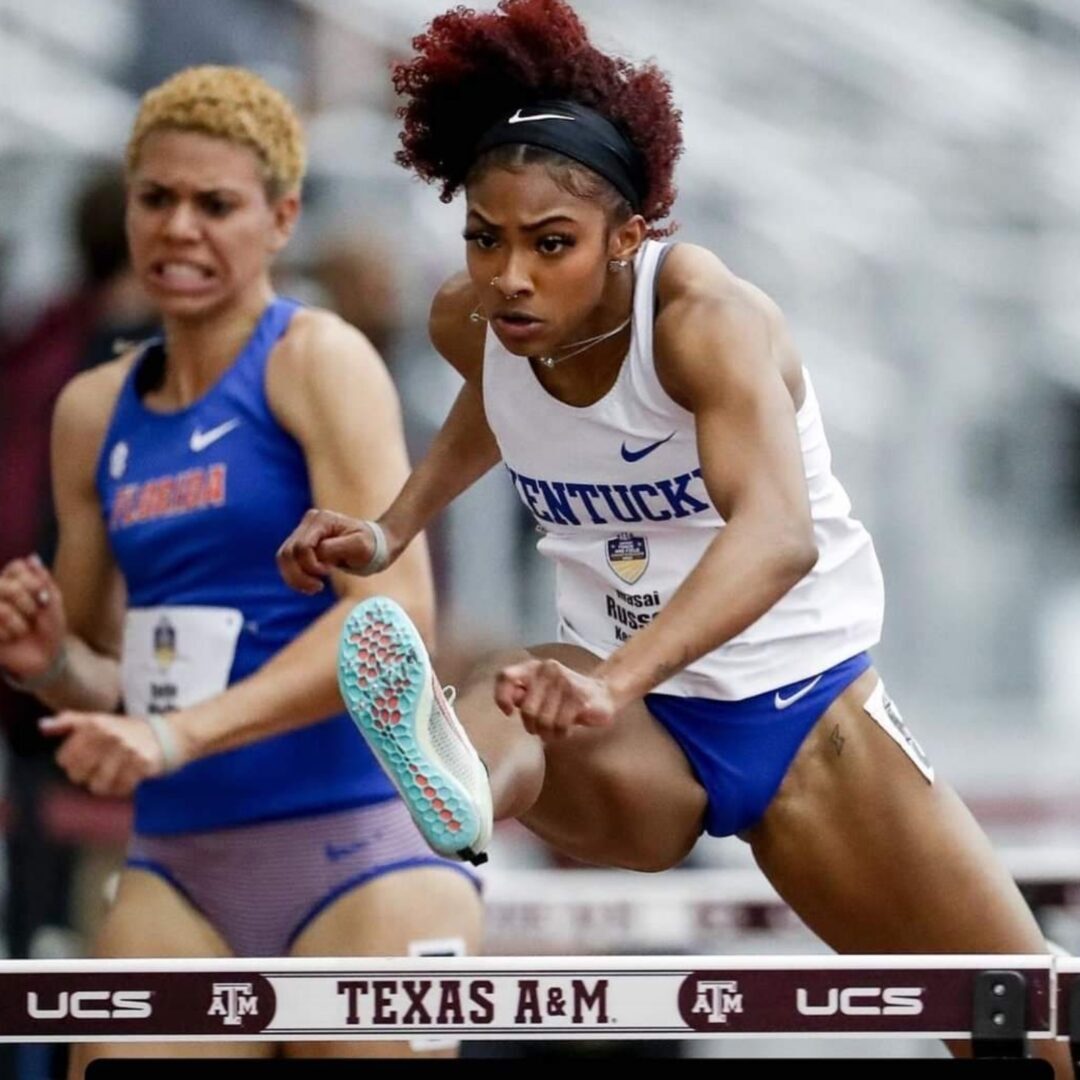 Female hurdler clearing hurdle during track competition